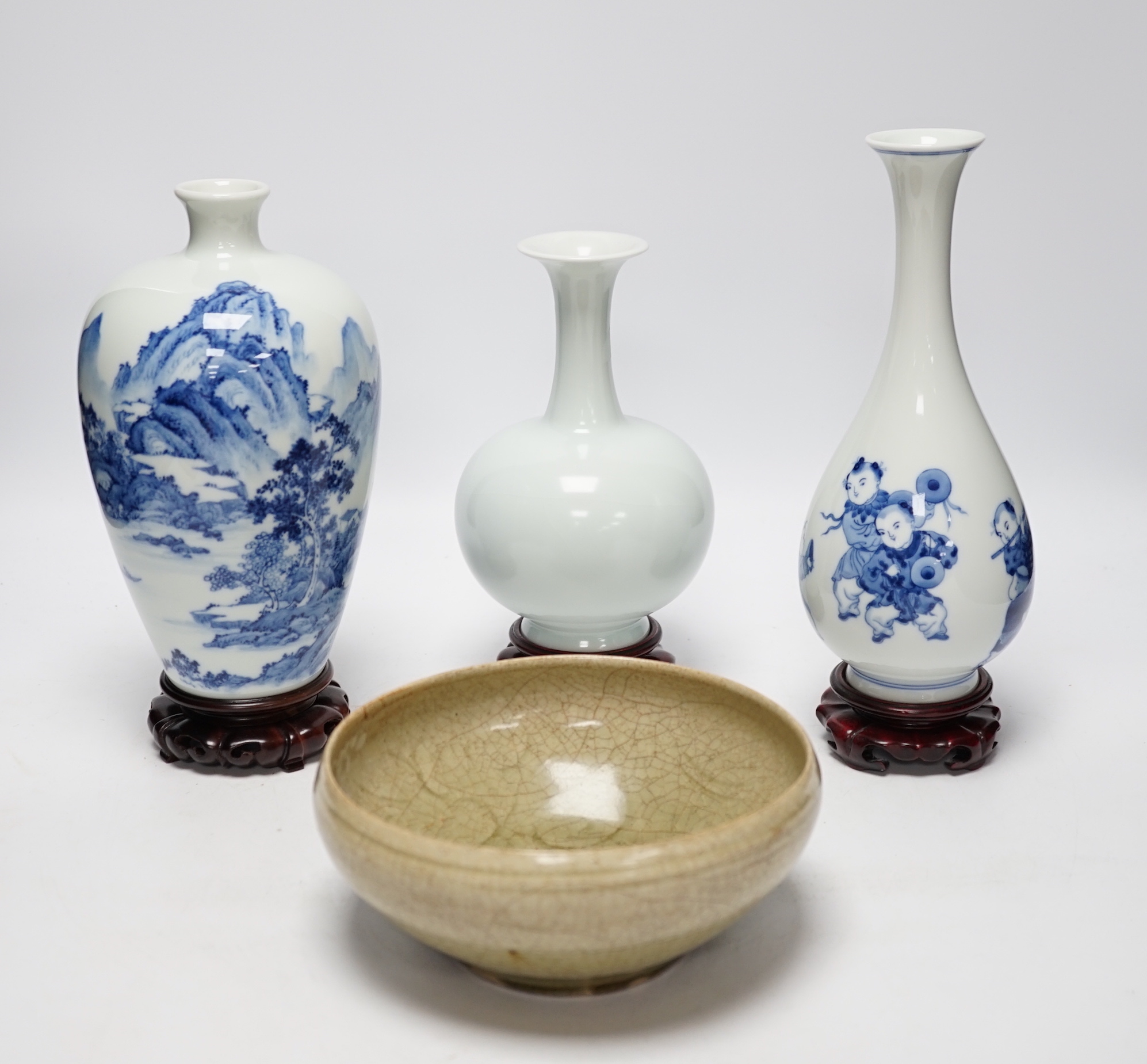 Two modern Chinese blue and white vases on stands, a crackle glaze celadon bowl and vase, tallest 26cm including stand